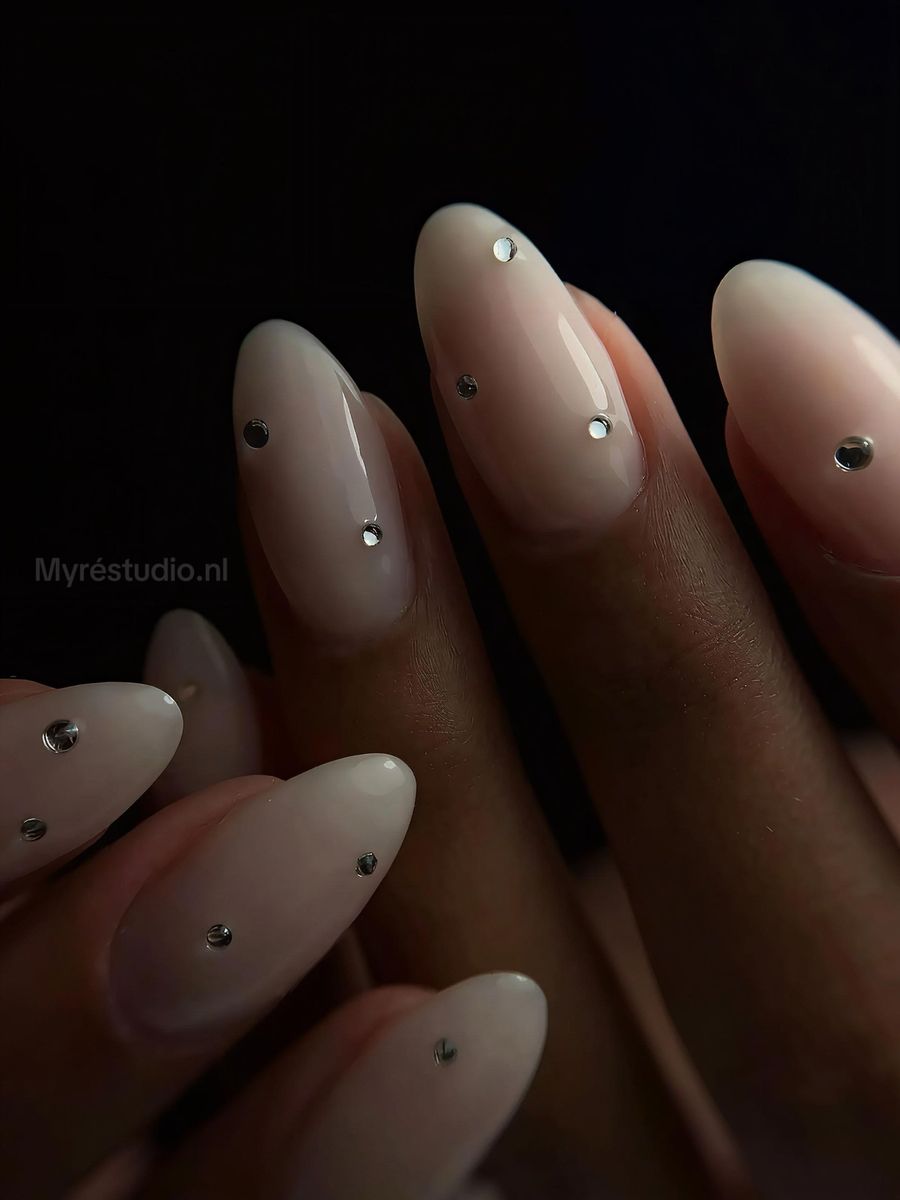 Melkwitte amandelnagels met kleine zilveren steentjes